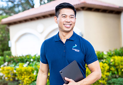 Man in polo shirt smiling while holding an ipad