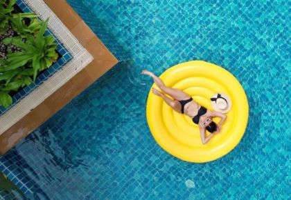 A woman practicing pool safety while floating on a raft.